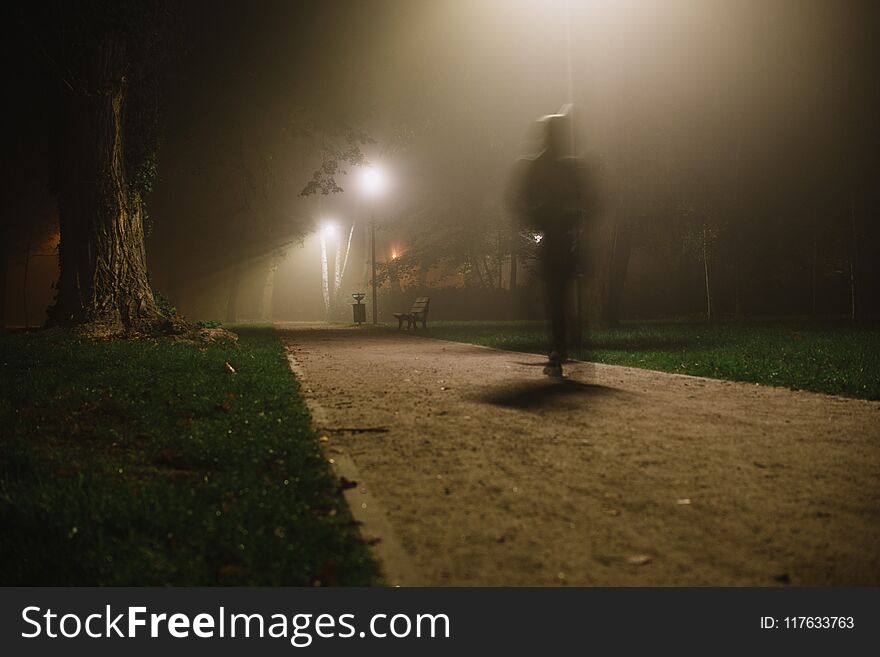 People motion blur in the park, night and heavy fog