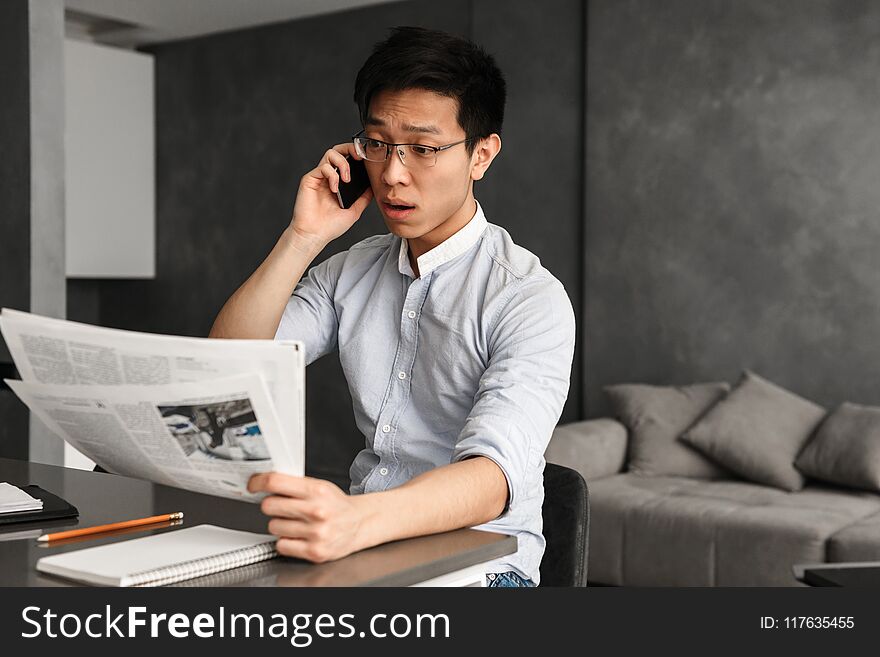 Emotional Young Asian Man Talking By Phone