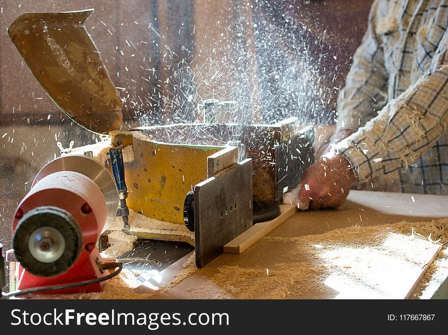 Carpenter tools on wooden table with sawdust. Circular Saw. Cutting a wooden plank.