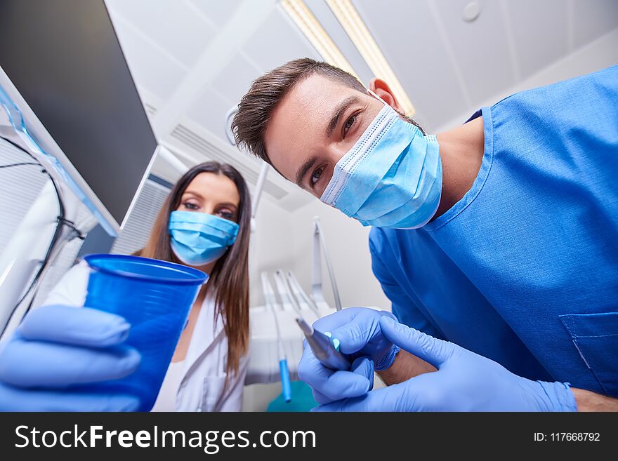 A handsome dentist and a beautiful assistant at a treatment, from the perspective of the patient. A handsome dentist and a beautiful assistant at a treatment, from the perspective of the patient.