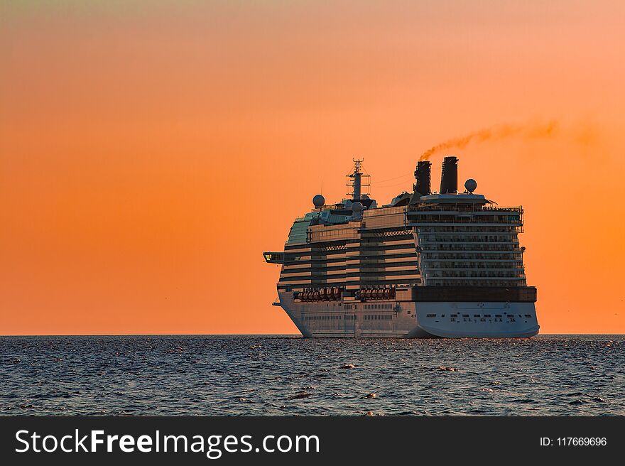 Giant brand new cruise liner against the gold sunset sky. Giant brand new cruise liner against the gold sunset sky