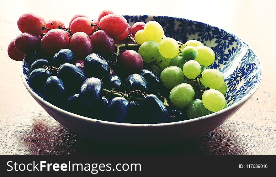 Red, Black, and Green Grapes in Round Blue and White Floral Ceramic Bowl