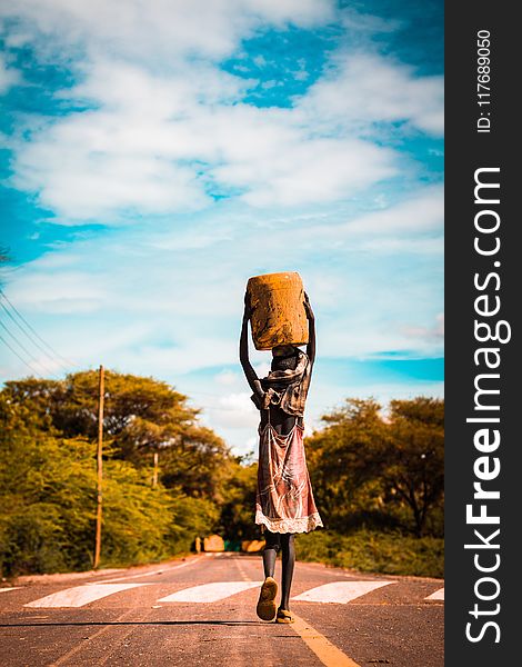 Person Carrying Container On The Head On Road