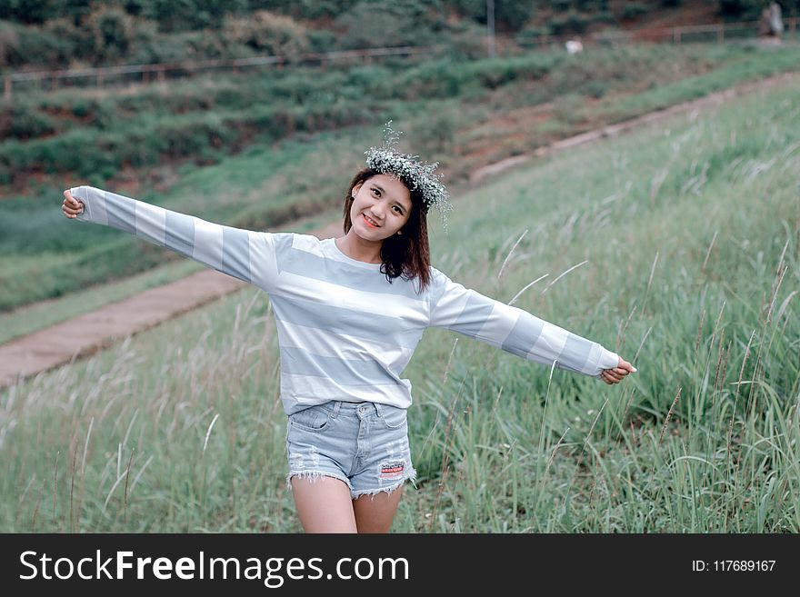 Selective Focus Photo Of Woman Wearing Gray And White Striped Sweatshirt Standing On Green Grass Fields