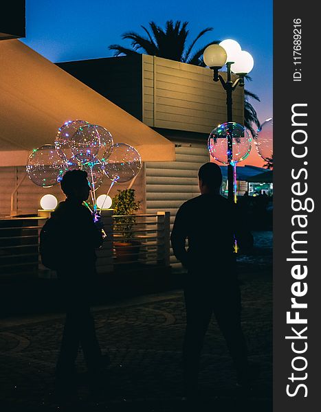 Silhouette Of Two People Holding Bubble Balloons