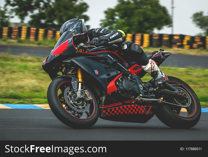 Man With Black Alpinestar Racing Suit Riding Black And Red Sports Bike