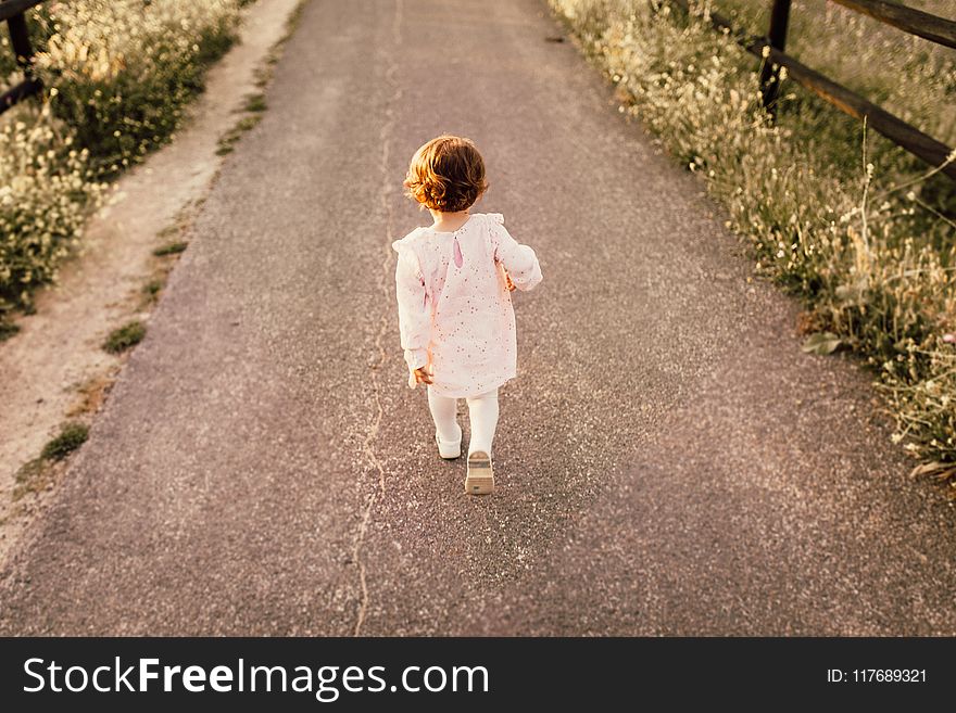Girl Wearing White Clothes Walking on Pavement Road