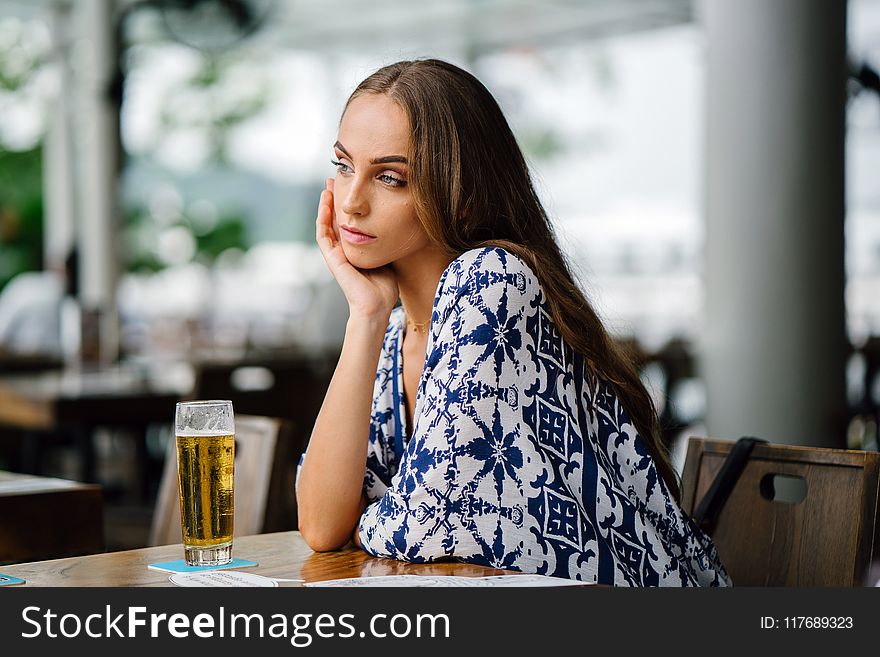 Woman in White and Blue Top Sitting in Front Table