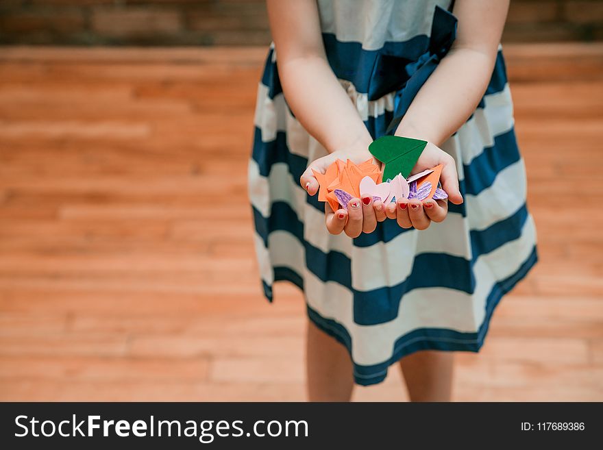Girl Holding Orange and Green Cut Papers