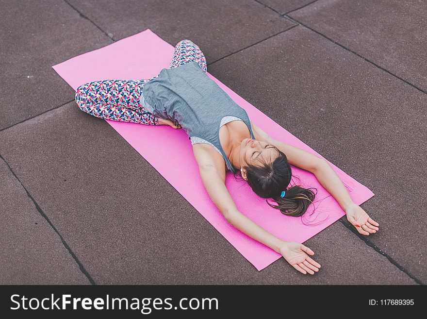 Woman Lying on Pink Yoga Mat