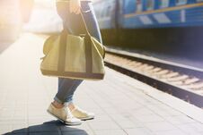 Woman Holding A Bag At A Train Station Stock Photo