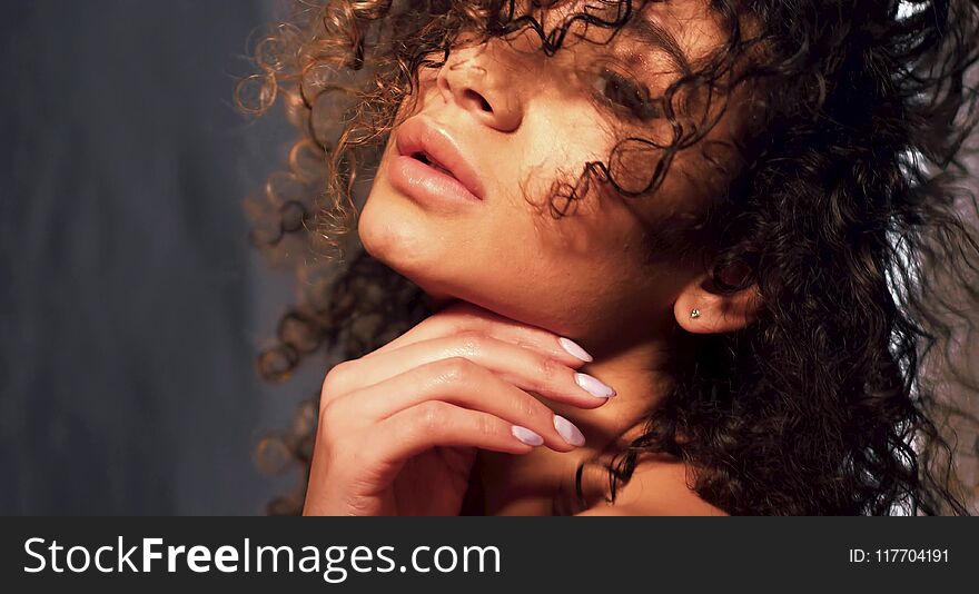 Face image of swarthy beautiful model with curly hair and cared skin. Beauty concept. Face image of swarthy beautiful model with curly hair and cared skin. Beauty concept.