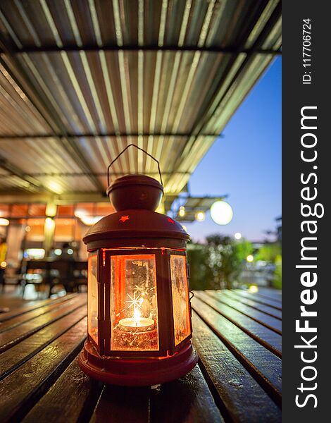 Abstract candle lantern light on wood table in blur bokeh pub restaurant dinner background concept for ramadan kareem night life, wooden tabletop dark indoor counter, happy kid mubarak.