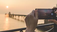 Female Photographing Sunset With Mobile Phone Royalty Free Stock Photos