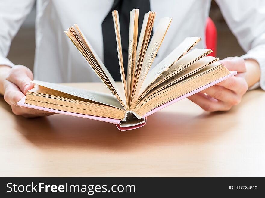 An open book an interesting novel in female hands closeup