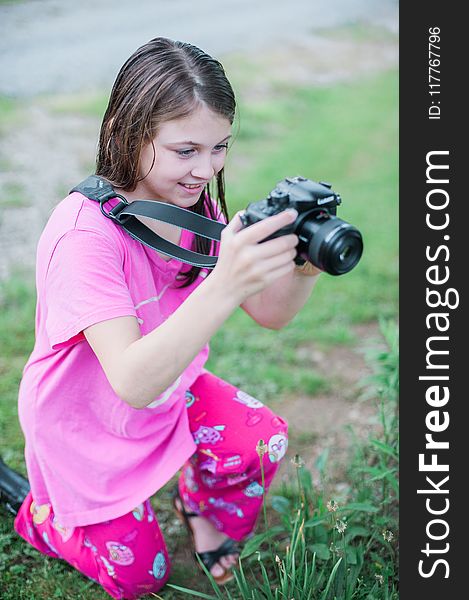 Shallow Focus Photo Of A Girl In Pink Round-neck Shirt Holding Black Dslr Camera