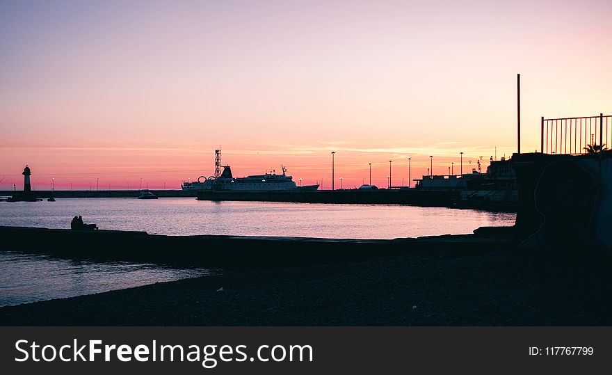 Silhouette Of Boat Dock Near Water During Dawn