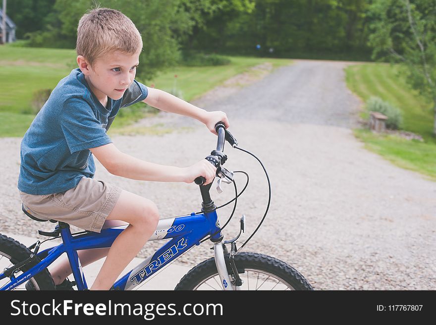 Boy Rides Blue Trek Bike at Daytime