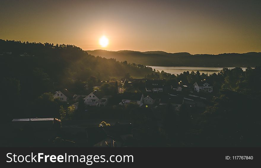 Village Near Mountain And Body Of Water