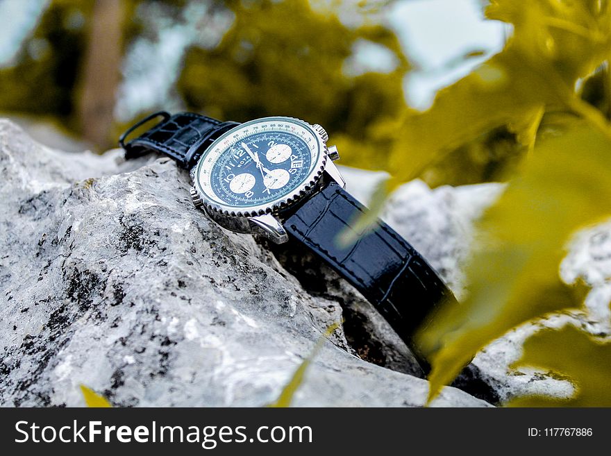 Selective Focus Photography of Chronograph Watch on Rock