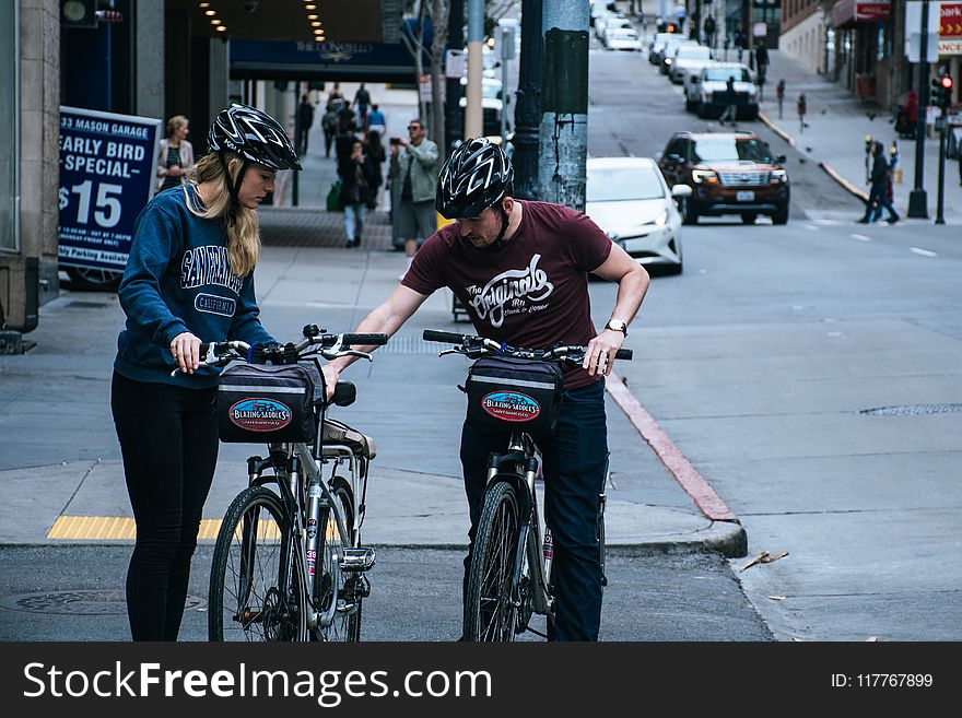 Man In Maroon Crew-neck T-shirt Beside Woman In Blue Sweatshirt At The Street