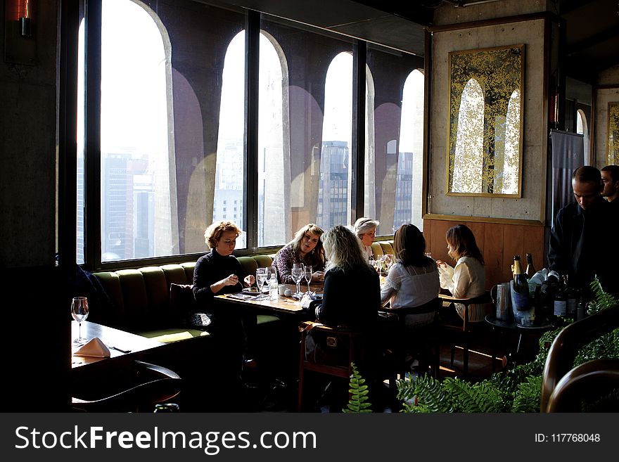 Group of People Sits Near Table