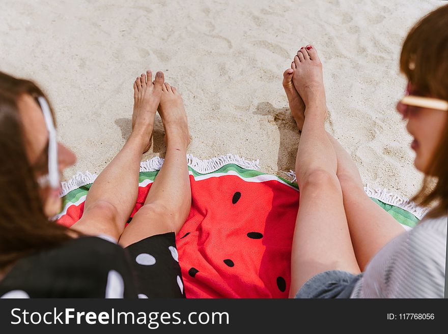 Two Person Sitting on Sand While Taking at Daytime