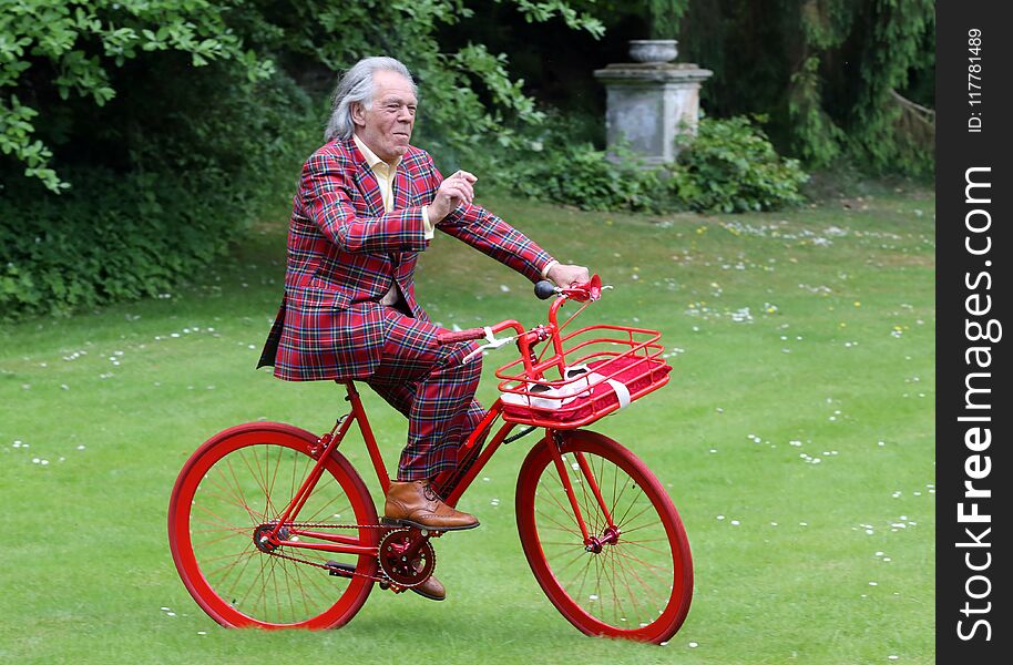 The bridegroom in a Scottish suit is looking forward to the red bike