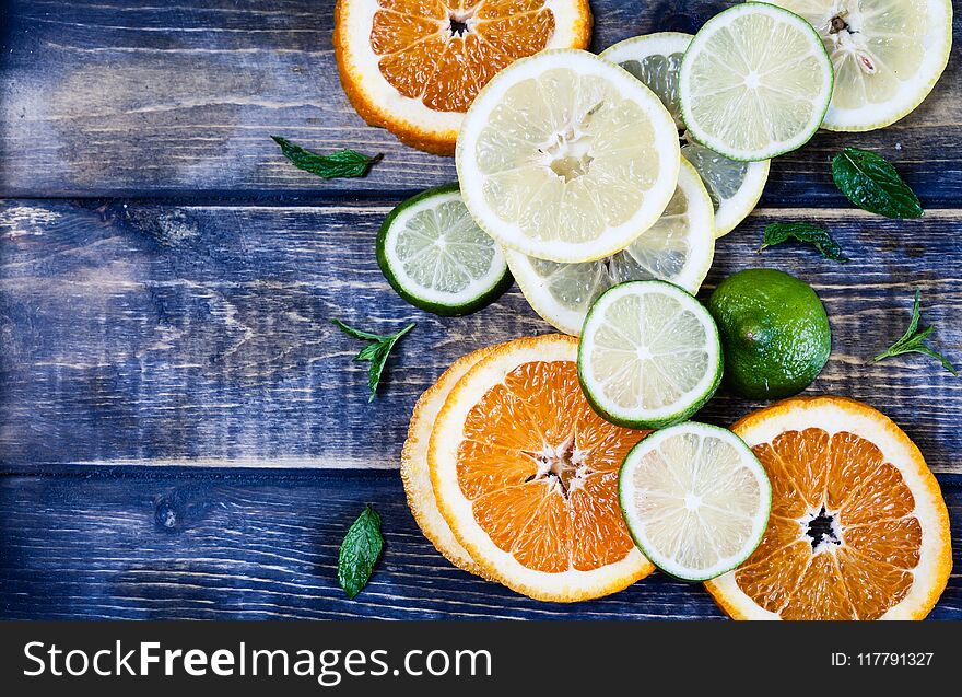 Artistic top view photo of different citruses - lemon, lime, orange - on rustic wooden background. Slices ripe fruits. Artistic top view photo of different citruses - lemon, lime, orange - on rustic wooden background. Slices ripe fruits.
