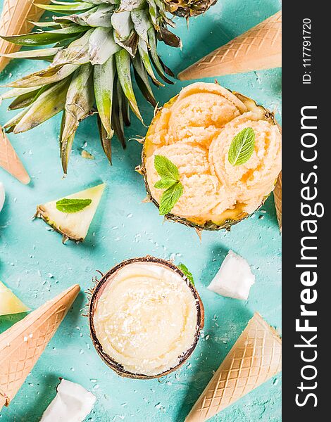 Summer holiday vacation concept, set various tropical ice cream sorbets, frozen juices in pineapple, grapefruit and coconut, light blue concrete background copy space