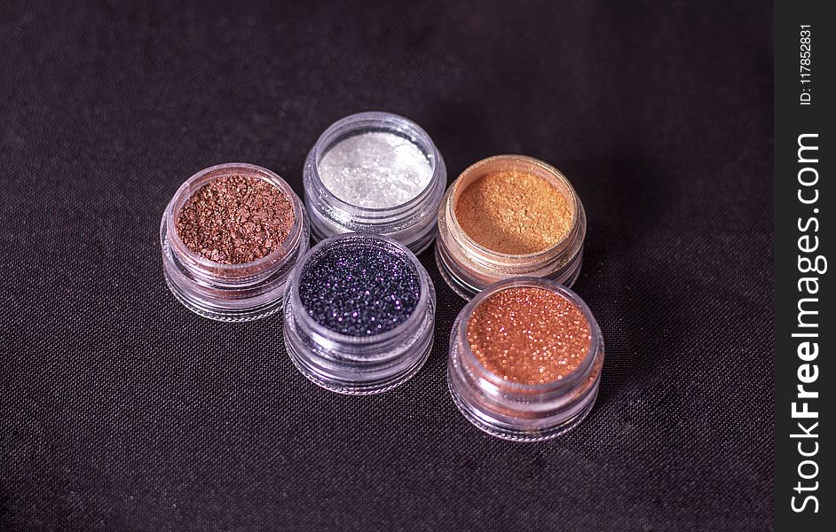 Close-Up Photo Of Glitters On Round Containers