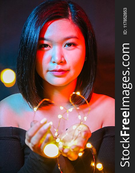 Woman Wearing Black Off-shoulder Top Holding String Lights