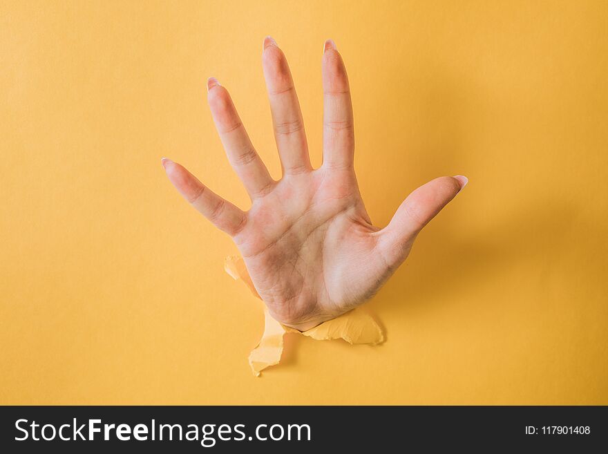 Girl Hand Breaks The Yellow Paper And Shows A Gesture