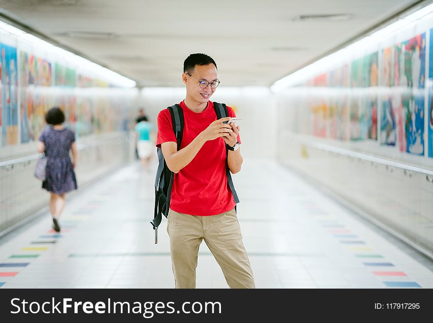 Man Wearing Red Crew-neck T-shirt And Brown Pants Photo