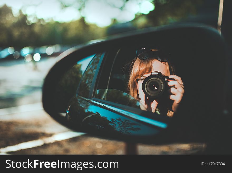 Selective Focus Photography of Woman Taking Camera Through Mirror