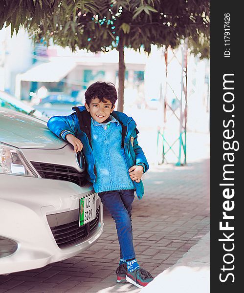 Photo of a Boy Leaning on Car