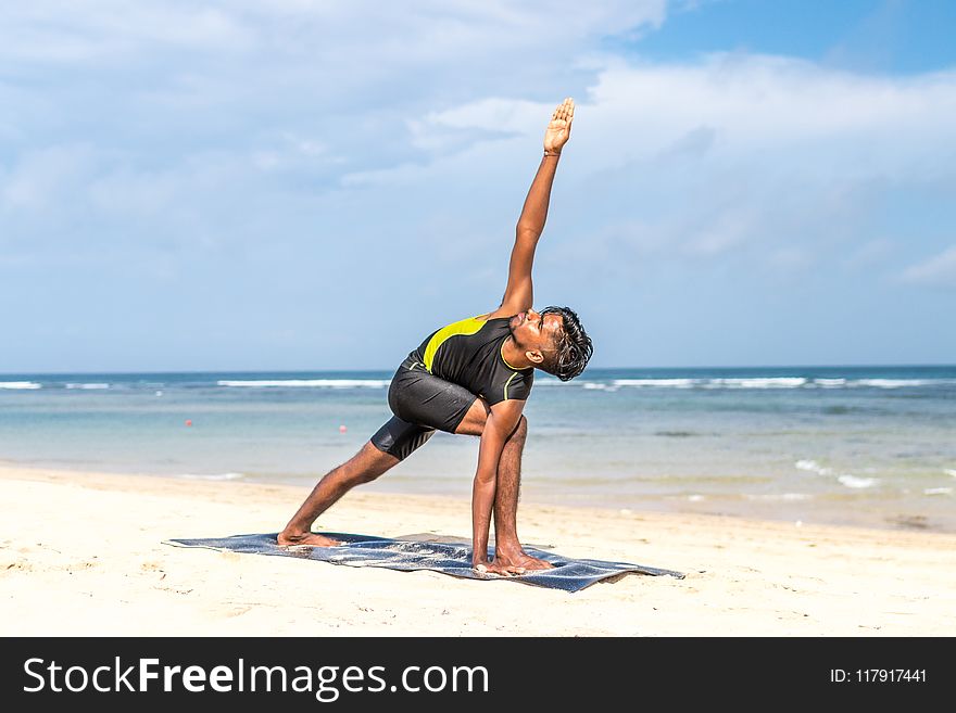 Man Doing Yoga Pose on Blue Mat Beside Seashore