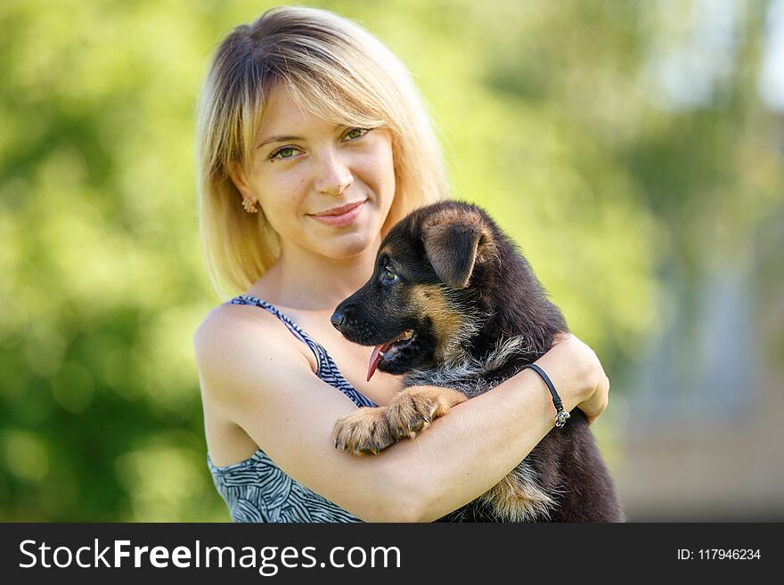 Young smiling woman with puppy of german shepherd