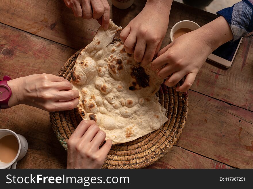 Six Hands Taking A Piece Of Delicious Naan