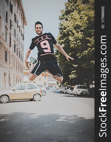 Photo of a Guy Jumping on Road