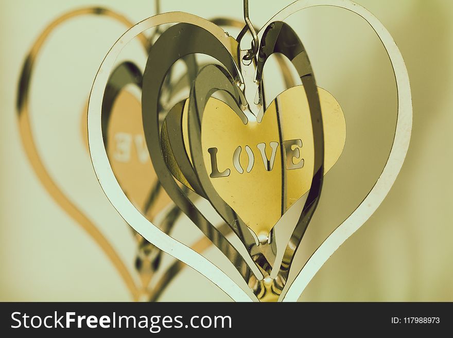 Shallow Focus Photography of Silver and Gold Heart Pendants