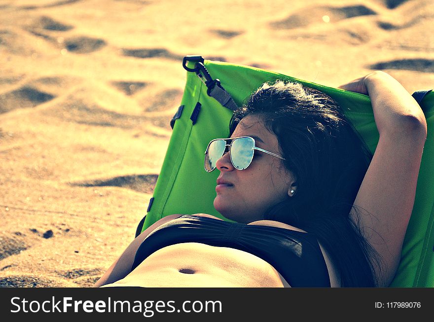 Woman Wearing Bikini Top Lying on Bed Beside Sand at Daytime