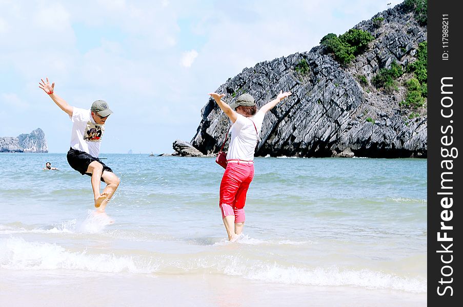 Woman And Man Playing On Seashore