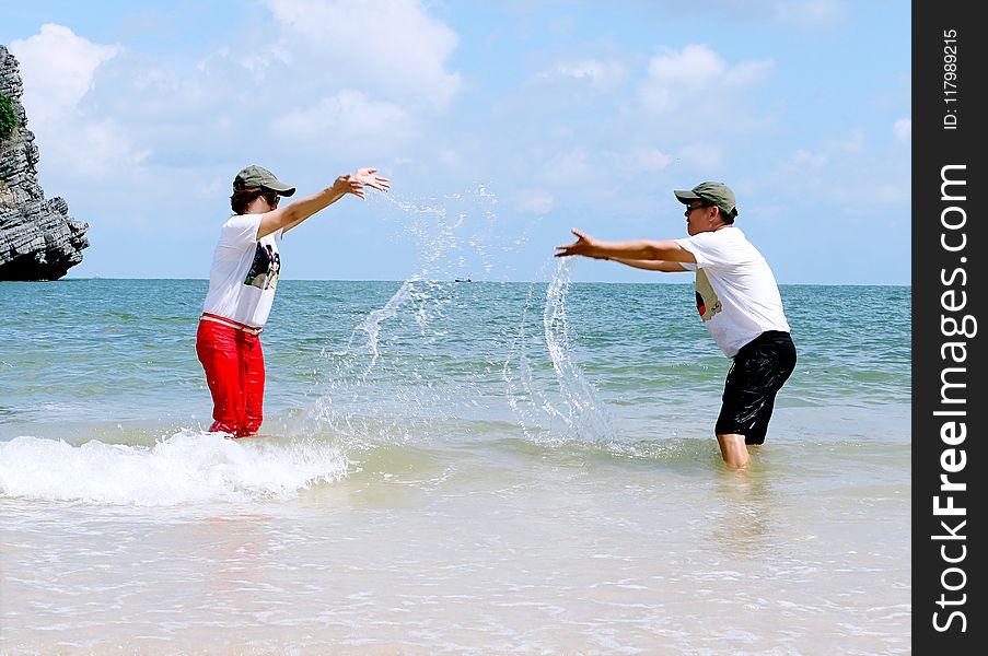 Man And Woman Splashing Water To Each Other