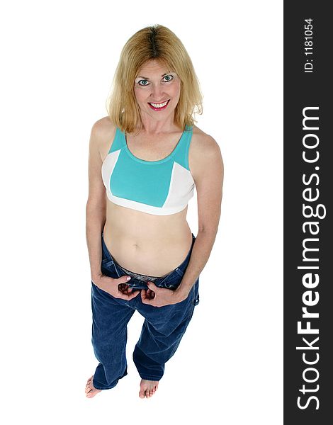 Beautiful freshly skinny middle aged blonde woman demonstrates how she has lost weight by showing how an old pair of pants has room to spare. Beautiful freshly skinny middle aged blonde woman demonstrates how she has lost weight by showing how an old pair of pants has room to spare.