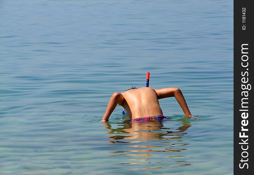 Kid in sea ready to dive and explore. Kid in sea ready to dive and explore