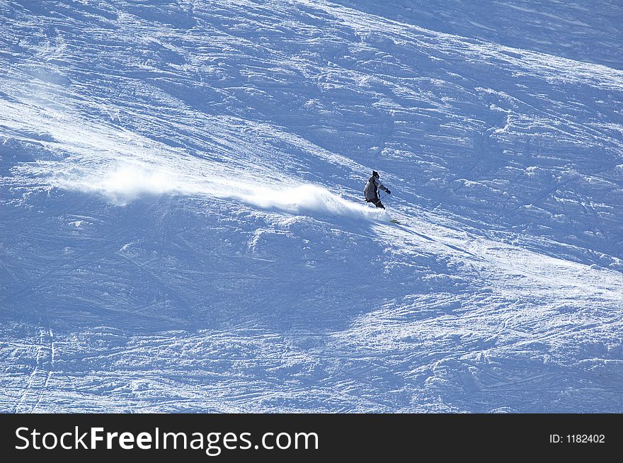 Mountain skier rush at full speed on flank of hill. Mountain skier rush at full speed on flank of hill