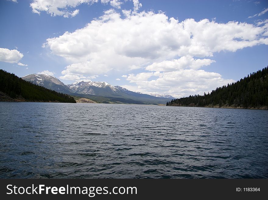 A reflective image on lake dillon higghlighted by the ten mile range and a blue sky accented by scattered clouds. A reflective image on lake dillon higghlighted by the ten mile range and a blue sky accented by scattered clouds