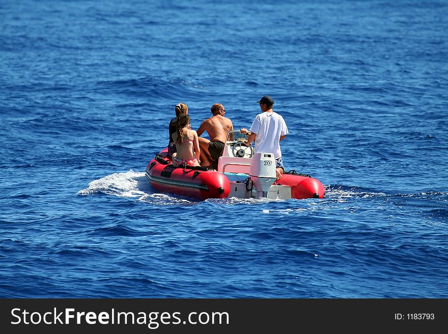 Four people on an inflatable boat, watching whales