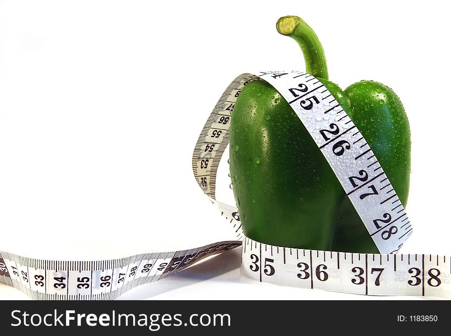 Measurement tape wrapped around green pepper/Concept for health, diet. Measurement tape wrapped around green pepper/Concept for health, diet